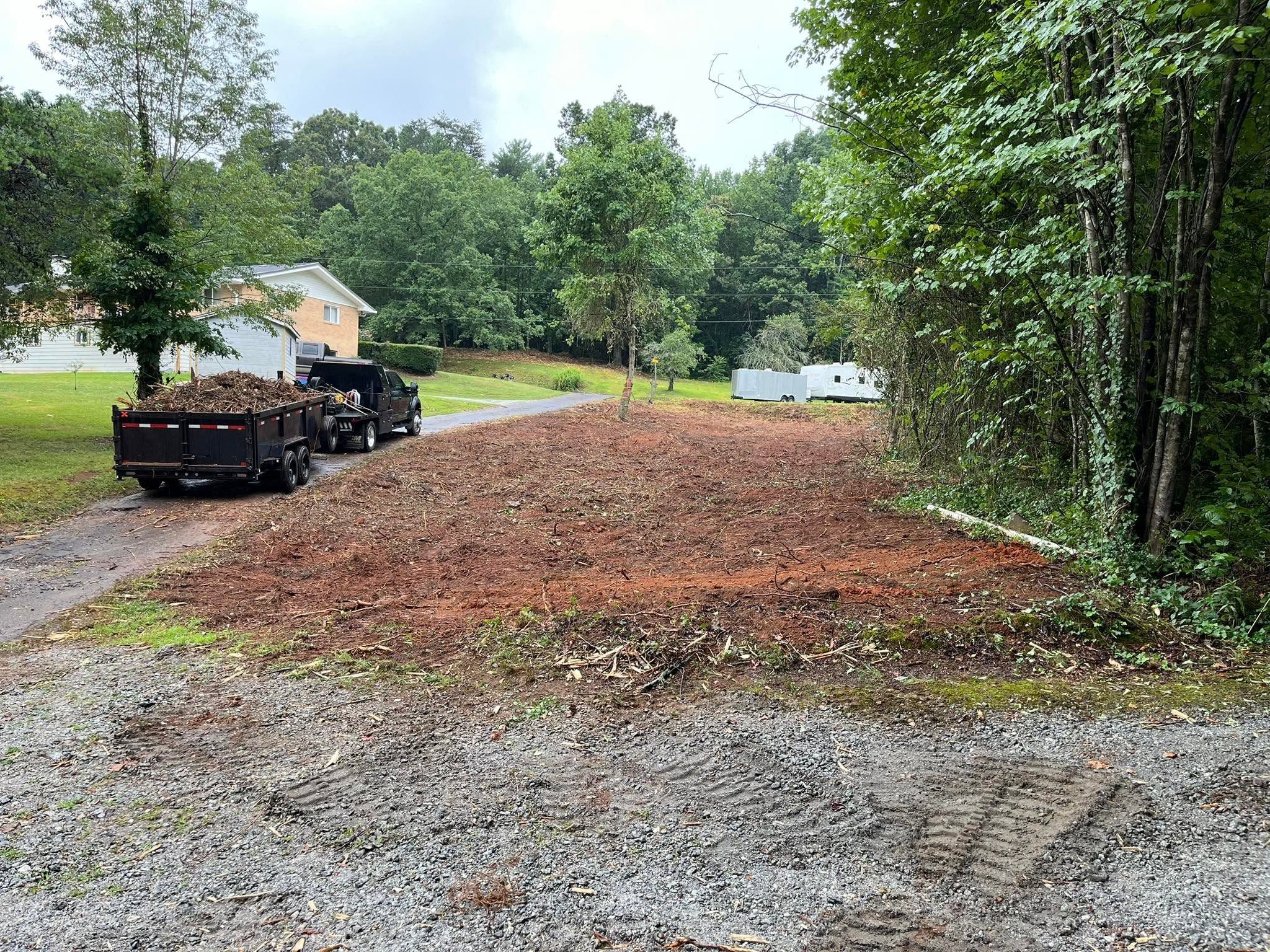 Cleared site with truck and dump trailer loaded with debris