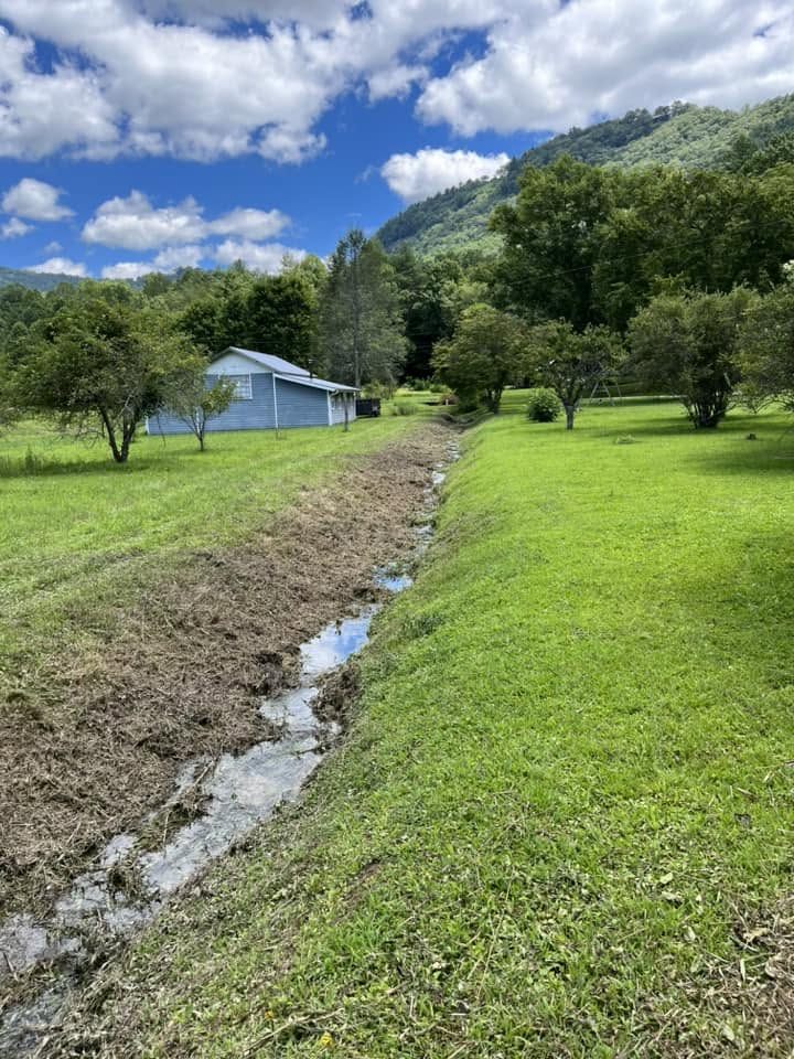 Finished drainage swale carrying water through a mountain property