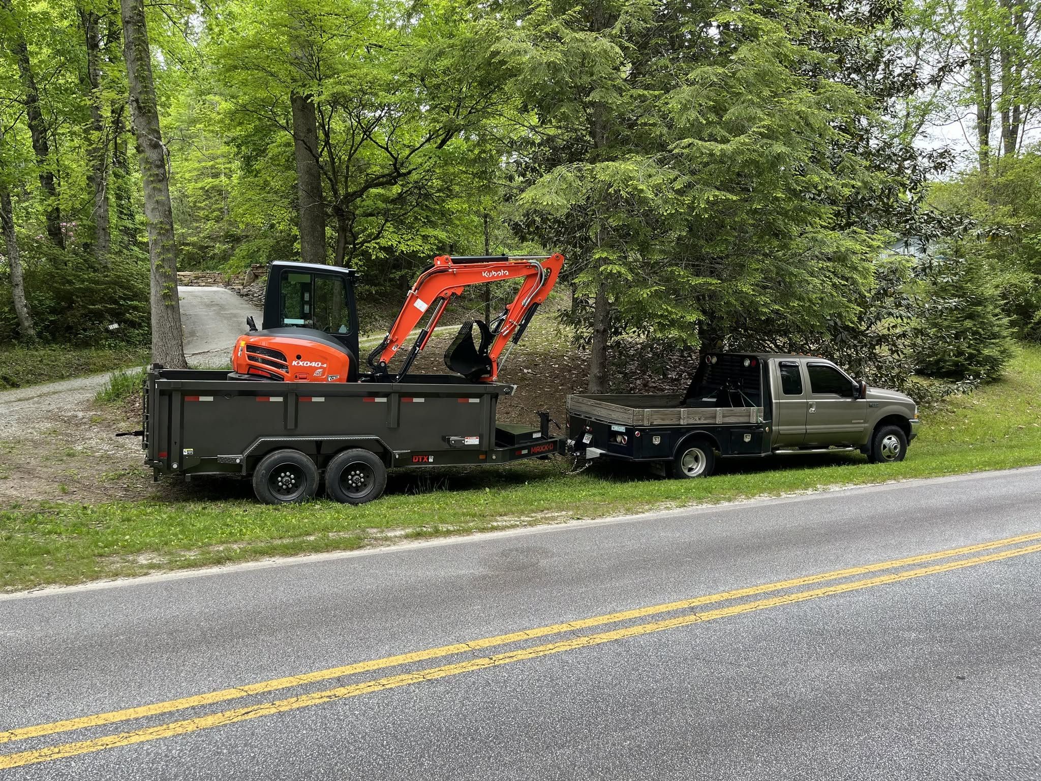 Mountain Tamer Kubota KX040-4 excavator loaded on a MAXX-D dump trailer behind a Ford Super Duty flatbed