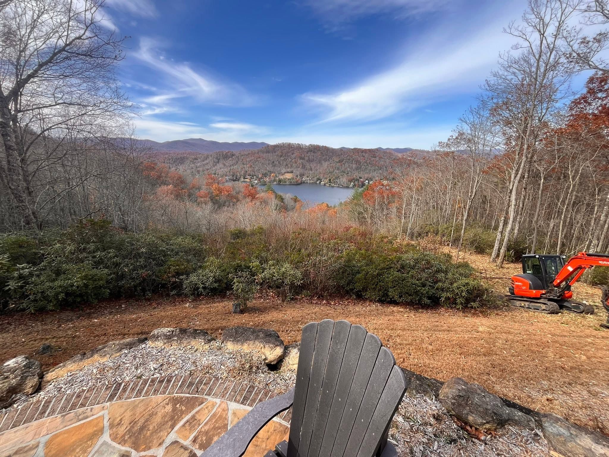 Excavator working on a mountain property overlooking a lake