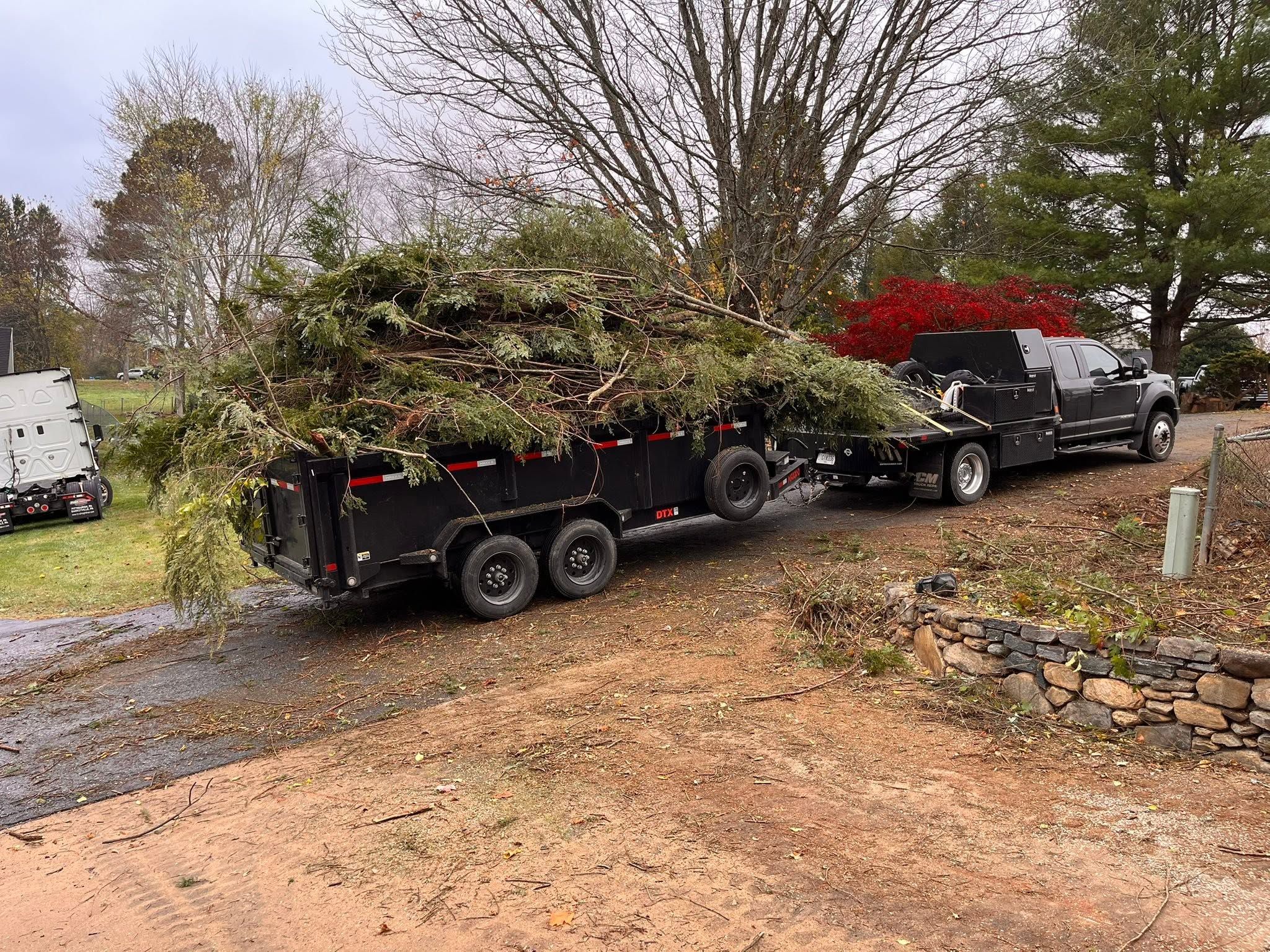 Ford Super Duty flatbed and MAXX-D dump trailer loaded with brush debris